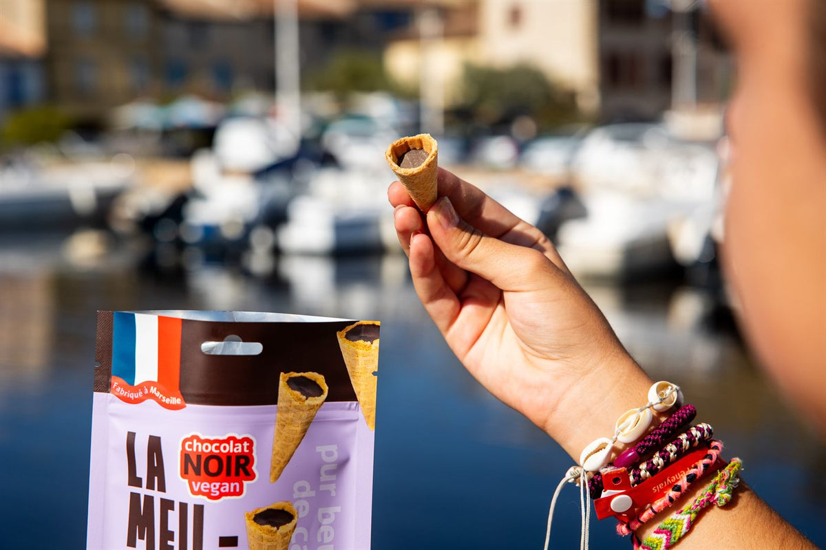 Mini cône au chocolat noir devant les bateaux