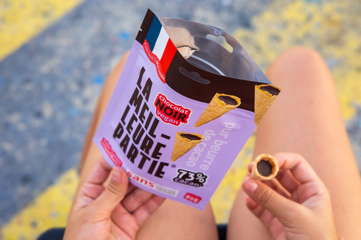 Vue d'en haut : on tient le sachet de mini cônes chocolat noir 73 % vegan et on pioche un mini cône
